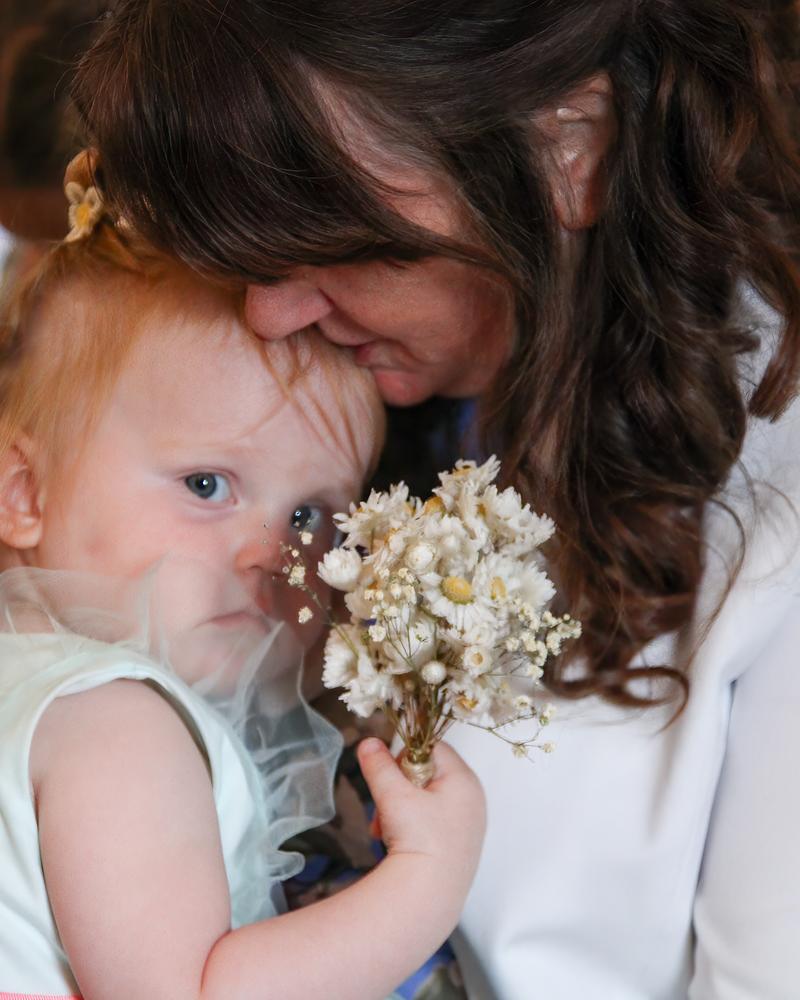 A grandmother hugging the flower girl