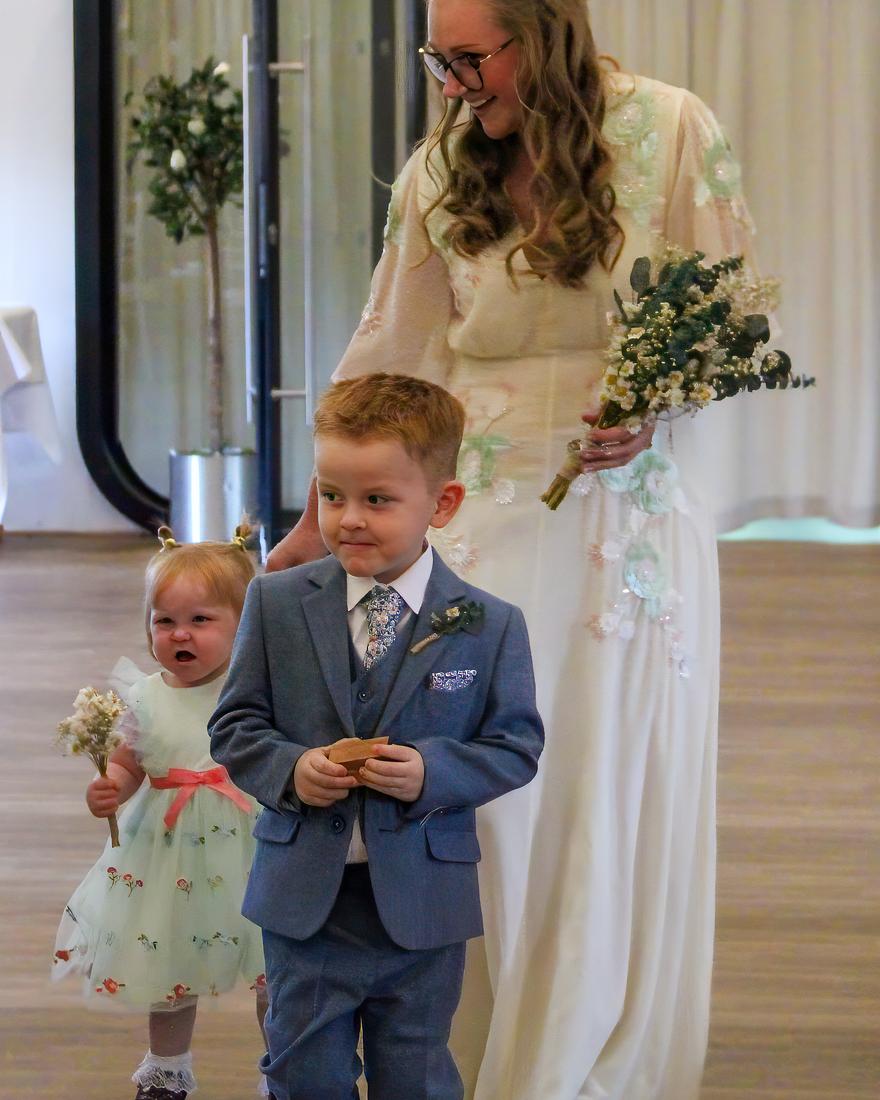 Bride walking in with her page boy and flower girl